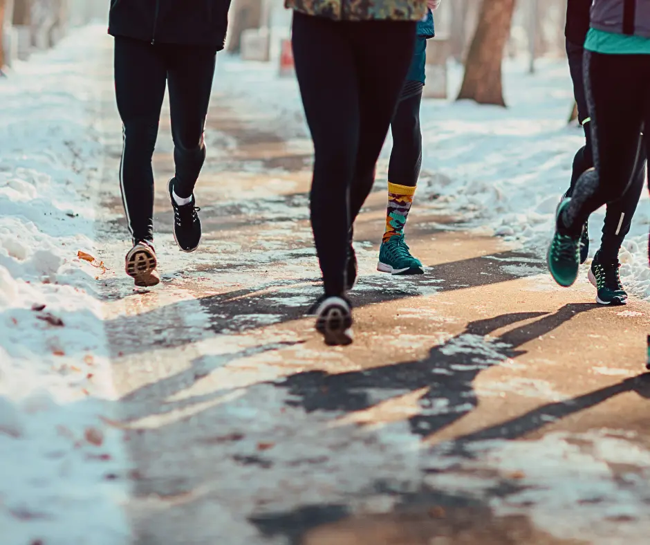 Image of five runners on a partially shoveled snowy winter sidewalk.